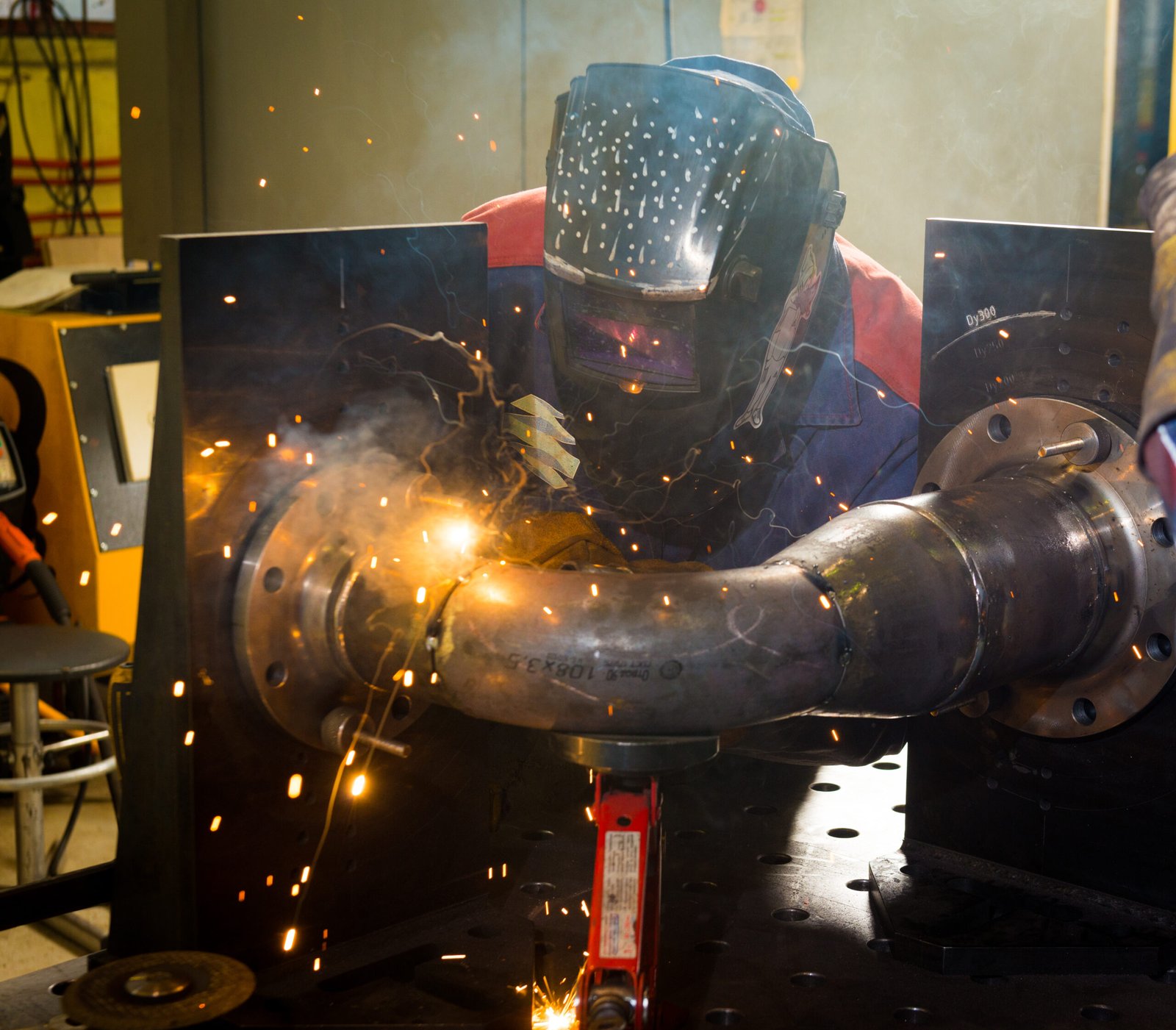 Welder using protective gear while working on a metal gate